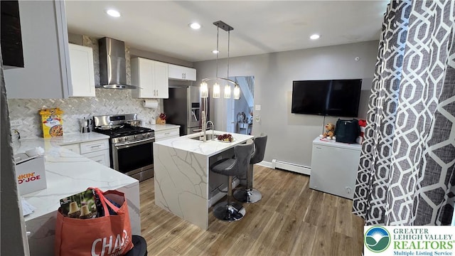 1500 Schuylkill Ave, Reading City, PA 19601 - kitchen featuring stainless steel appliances, wall chimney range hood, baseboard heating, light wood-style flooring, and recessed lighting