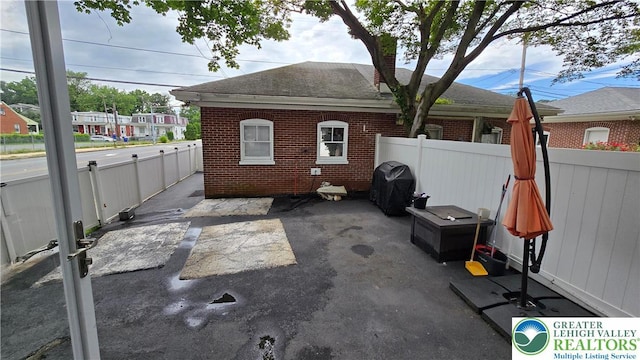 1500 Schuylkill Ave, Reading City, PA 19601 - back of property featuring brick siding, a patio area, and roof with shingles