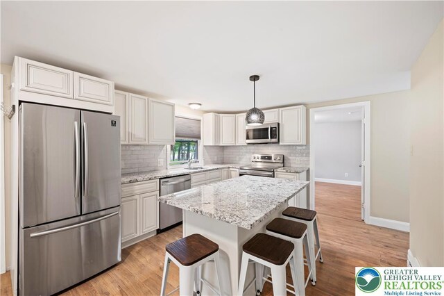 29 Long Brook Way, Penn Forest Twp, PA 18210 - kitchen with appliances with stainless steel finishes, tasteful backsplash, a center island, and a kitchen bar