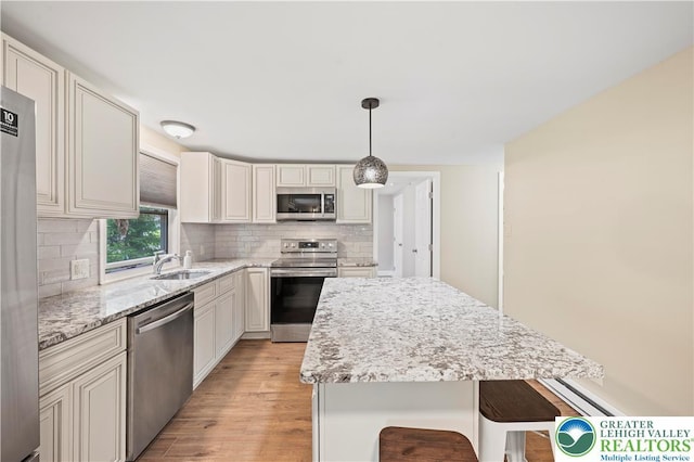 29 Long Brook Way, Penn Forest Twp, PA 18210 - kitchen with appliances with stainless steel finishes, decorative backsplash, light wood-style flooring, and light stone counters