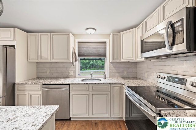 29 Long Brook Way, Penn Forest Twp, PA 18210 - kitchen with appliances with stainless steel finishes, backsplash, light stone countertops, light wood-type flooring, and cream cabinetry