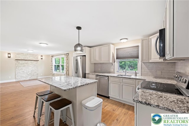 29 Long Brook Way, Penn Forest Twp, PA 18210 - kitchen featuring stainless steel appliances, light wood finished floors, a kitchen bar, decorative backsplash, and a kitchen island