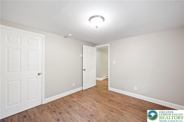 29 Long Brook Way, Penn Forest Twp, PA 18210 - unfurnished bedroom with wood finished floors and a baseboard radiator