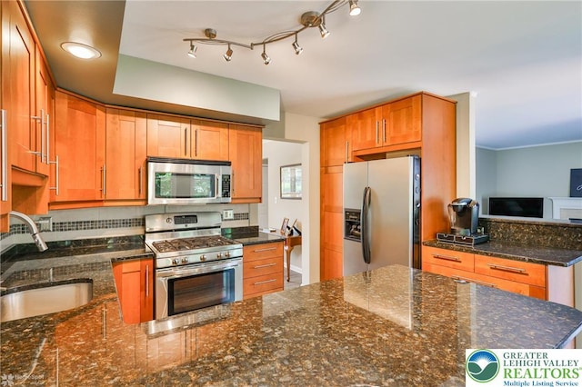 1945 Jenkins Dr, Forks Twp, PA 18040 - kitchen featuring stainless steel appliances, dark stone countertops, a peninsula, and brown cabinets