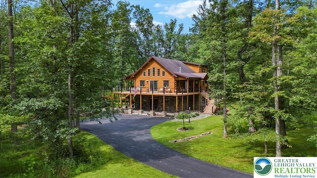 207 W Douglasville Rd, Bushkill Twp, PA 18064 - view of front of property with asphalt driveway, a front yard, a deck, stairway, and a wooded view