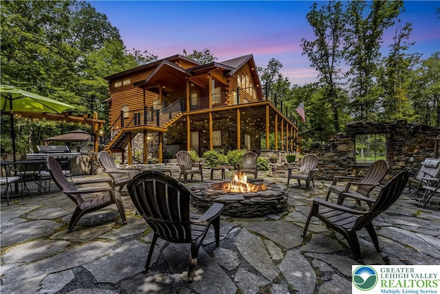 207 W Douglasville Rd, Bushkill Twp, PA 18064 - patio terrace at dusk with a fire pit, stairs, a patio area, and a balcony