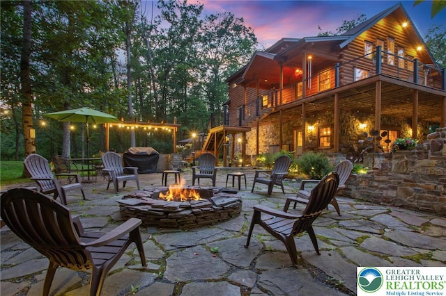 207 W Douglasville Rd, Bushkill Twp, PA 18064 - patio terrace at dusk with a fire pit, a balcony, a patio area, and grilling area