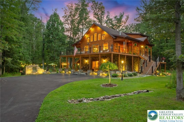 207 W Douglasville Rd, Bushkill Twp, PA 18064 - view of front facade with stairway, stone siding, asphalt driveway, a front yard, and log exterior