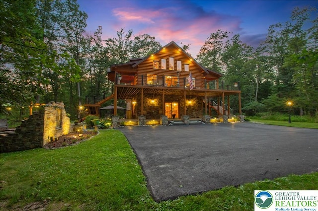 207 W Douglasville Rd, Bushkill Twp, PA 18064 - log cabin featuring stairs, a deck, a front yard, driveway, and log siding