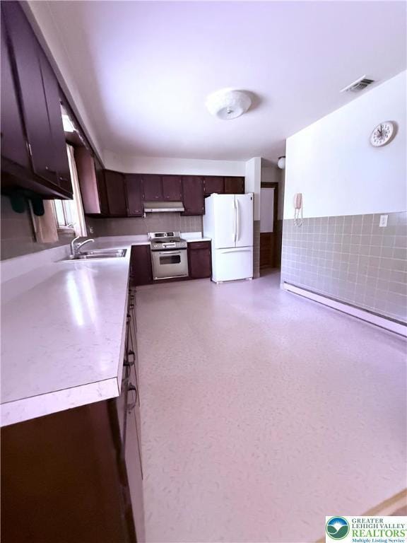 4395 E Texas Rd, Lower Macungie Twp, PA 18103 - kitchen featuring freestanding refrigerator, stainless steel range, under cabinet range hood, light countertops, and dark brown cabinets