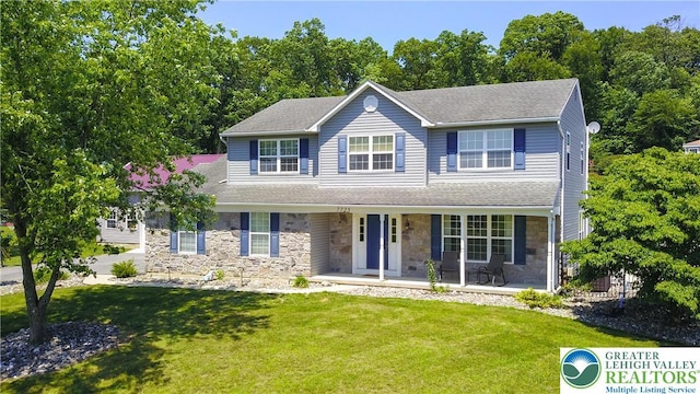7725 Harbor Ct, Washington Twp, PA 18080 - colonial inspired home featuring stone siding, covered porch, a front lawn, and a shingled roof
