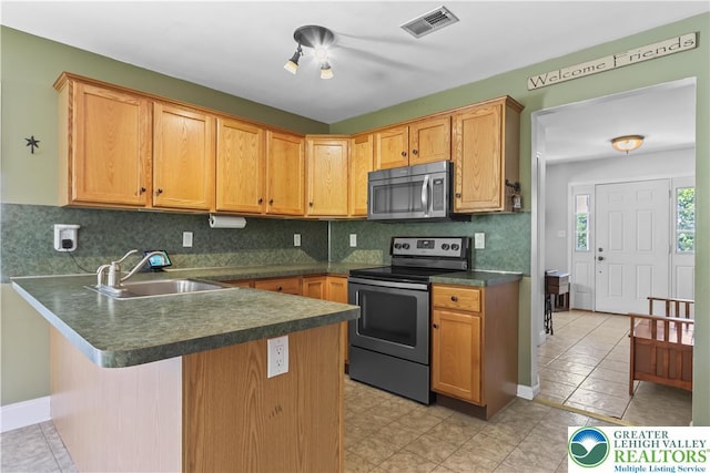 7725 Harbor Ct, Washington Twp, PA 18080 - kitchen featuring stainless steel appliances, dark countertops, a peninsula, tasteful backsplash, and a breakfast bar