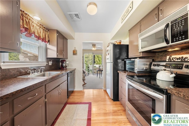 7 Rosemont Ct, Palmer Twp, PA 18045 - kitchen featuring stainless steel appliances, dark countertops, tasteful backsplash, light wood-style flooring, and a ceiling fan