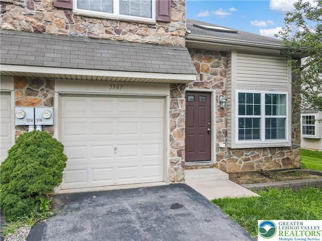 5587 Stonecroft Ln, Lower Macungie Twp, PA 18106 - property entrance with stone siding, roof with shingles, a garage, and asphalt driveway
