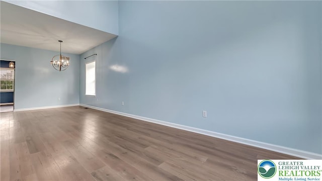 5587 Stonecroft Ln, Lower Macungie Twp, PA 18106 - empty room featuring a chandelier and dark wood finished floors