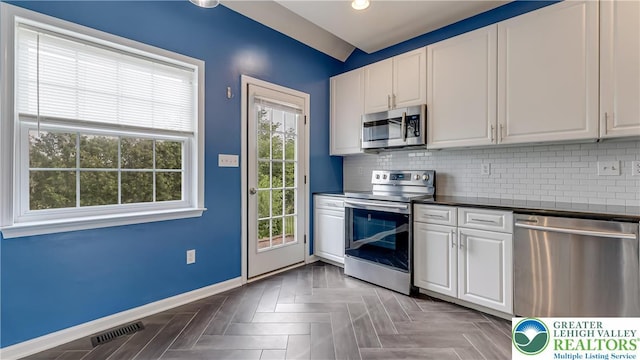 5587 Stonecroft Ln, Lower Macungie Twp, PA 18106 - kitchen with stainless steel appliances, dark countertops, white cabinets, backsplash, and recessed lighting