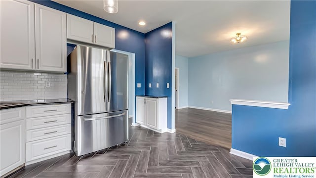 5587 Stonecroft Ln, Lower Macungie Twp, PA 18106 - kitchen featuring freestanding refrigerator, dark countertops, white cabinetry, decorative backsplash, and recessed lighting