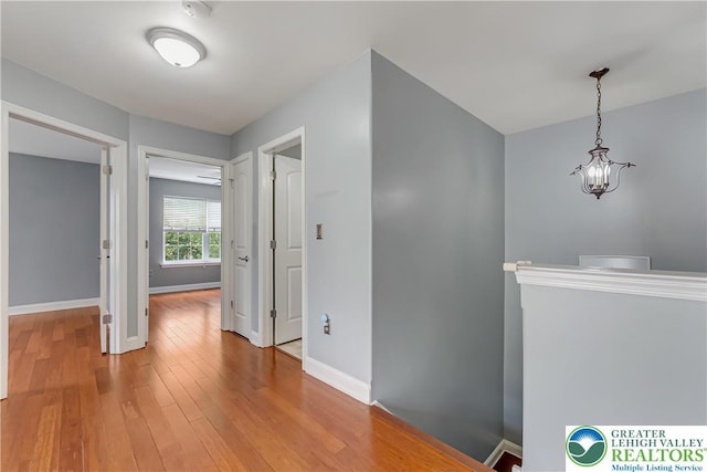 6945 Hunt Dr, Lower Macungie Twp, PA 18062 - hall with light wood-style floors, an upstairs landing, and a chandelier