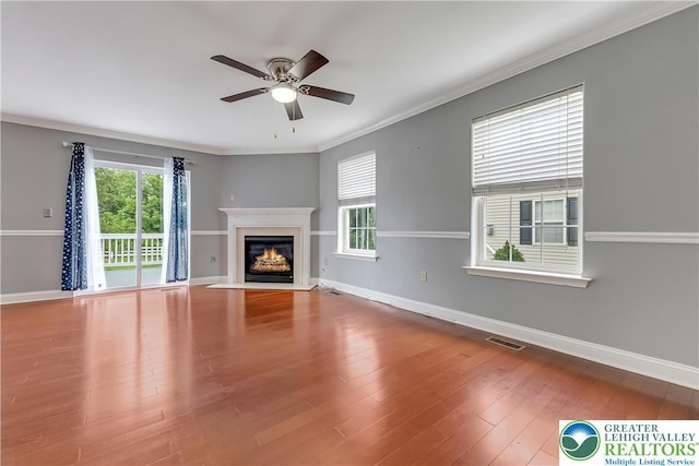 6945 Hunt Dr, Lower Macungie Twp, PA 18062 - unfurnished living room featuring ceiling fan, a fireplace with flush hearth, crown molding, and wood finished floors