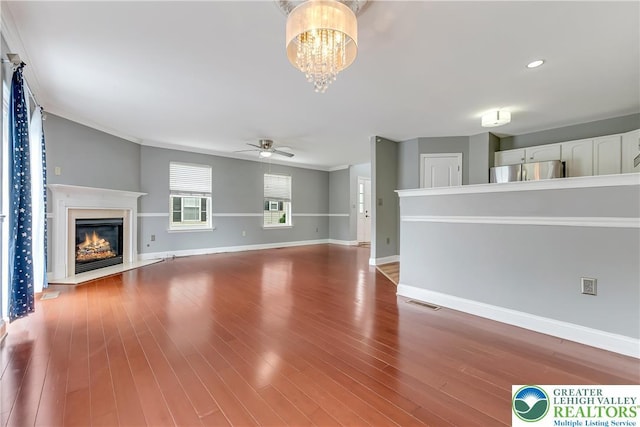 6945 Hunt Dr, Lower Macungie Twp, PA 18062 - unfurnished living room with ceiling fan, a chandelier, a glass covered fireplace, wood finished floors, and recessed lighting