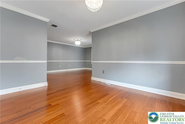 6945 Hunt Dr, Lower Macungie Twp, PA 18062 - unfurnished room with wood finished floors, a chandelier, and ornamental molding