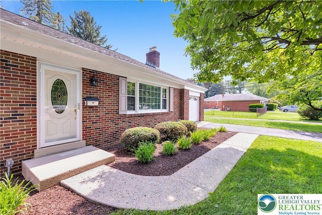 3032 W Woodlawn St, South Whitehall Twp, PA 18104 - property entrance with brick siding, a lawn, and a chimney