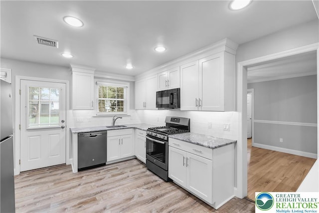 3032 W Woodlawn St, South Whitehall Twp, PA 18104 - kitchen with appliances with stainless steel finishes, white cabinets, light stone counters, decorative backsplash, and recessed lighting