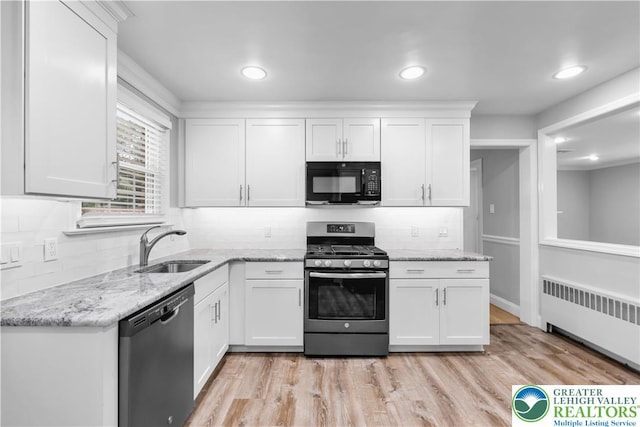 3032 W Woodlawn St, South Whitehall Twp, PA 18104 - kitchen featuring dishwasher, black microwave, radiator heating unit, gas stove, and tasteful backsplash