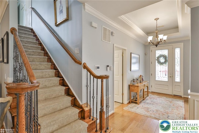 4076 Pine Hurst Dr, Allen Twp, PA 18067 - foyer entrance with stairway, light wood-type flooring, a chandelier, a tray ceiling, and crown molding