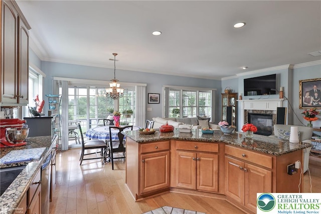 4076 Pine Hurst Dr, Allen Twp, PA 18067 - kitchen with a high end fireplace, dark stone counters, light wood finished floors, ornamental molding, and decorative light fixtures