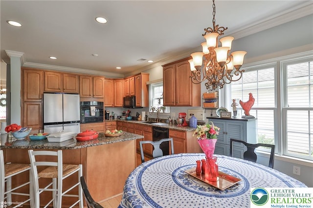 4076 Pine Hurst Dr, Allen Twp, PA 18067 - kitchen with black appliances, ornamental molding, a chandelier, dark stone counters, and a center island