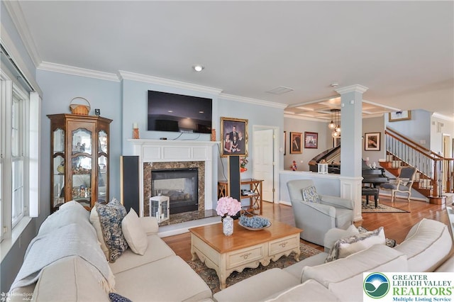 4076 Pine Hurst Dr, Allen Twp, PA 18067 - living area featuring stairs, ornamental molding, wood finished floors, a premium fireplace, and ornate columns