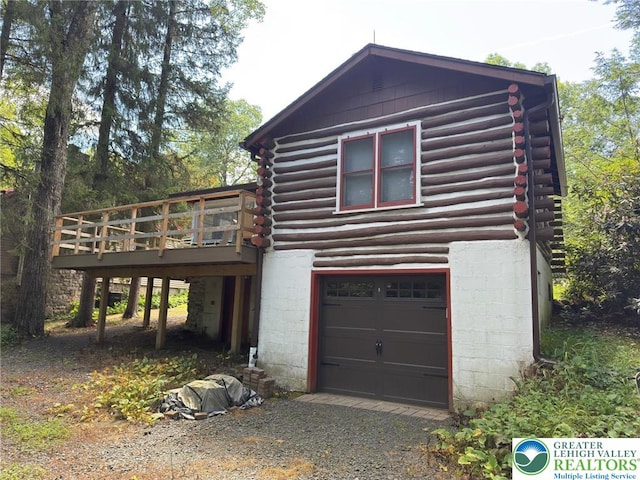 521 Resica Falls Rd, East Stroudsburg, PA 18302 - view of home's exterior featuring log exterior, an attached garage, driveway, and a deck