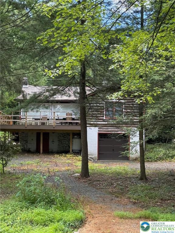 521 Resica Falls Rd, East Stroudsburg, PA 18302 - back of house with a wooden deck, a garage, and dirt driveway