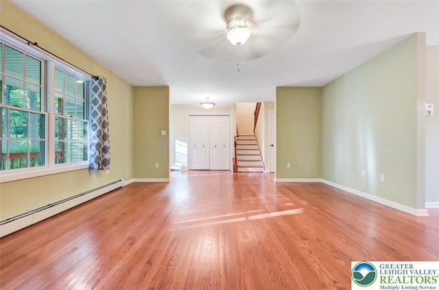 119 Savage Trl, Smithfield Twp, PA 18301 - unfurnished room with a baseboard heating unit, stairway, wood finished floors, and a ceiling fan