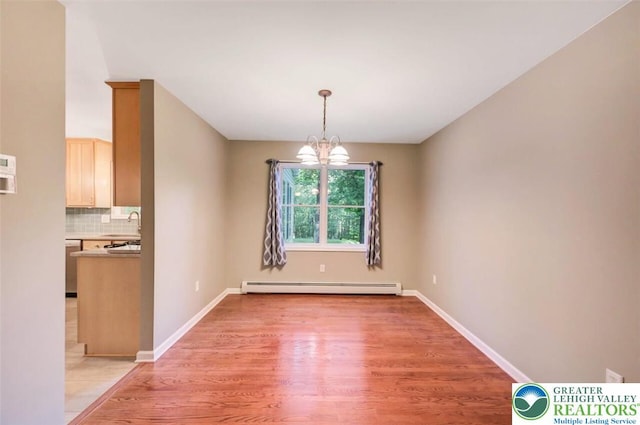 119 Savage Trl, Smithfield Twp, PA 18301 - unfurnished dining area with a baseboard heating unit, light wood finished floors, and a chandelier