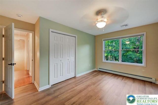 119 Savage Trl, Smithfield Twp, PA 18301 - unfurnished bedroom featuring a baseboard radiator, attic access, wood finished floors, a closet, and a ceiling fan