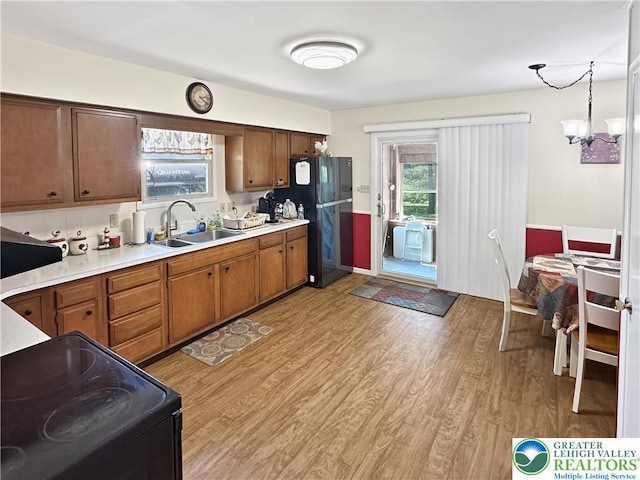 7537 Lake Shore Dr, Tobyhanna Twp, PA 18347 - kitchen featuring black appliances, light wood-style flooring, light countertops, and brown cabinetry