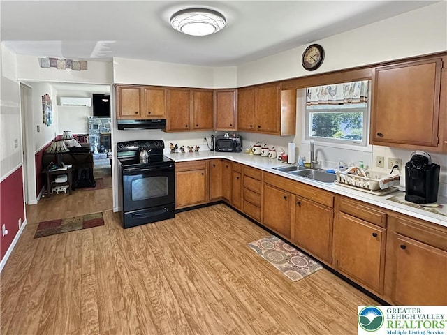 7537 Lake Shore Dr, Tobyhanna Twp, PA 18347 - kitchen featuring black appliances, a wall unit AC, light wood-style flooring, and light countertops