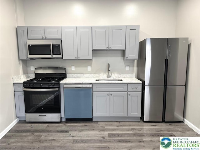 801 W Broad, Bethlehem City, PA 18018 - kitchen with stainless steel appliances, gray cabinetry, light wood finished floors, and light stone counters