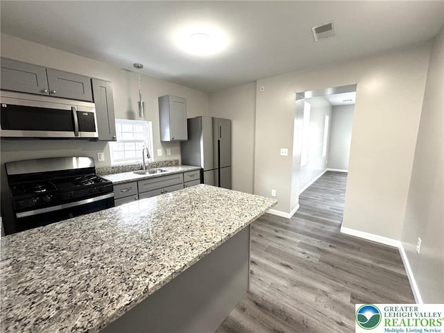 801 W Broad, Bethlehem City, PA 18018 - kitchen with appliances with stainless steel finishes, gray cabinets, light stone counters, and wood finished floors