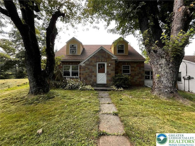 5984 Rte 412, Springfield Twp, PA 18077 - cape cod house featuring stone siding, a front yard, and a shingled roof