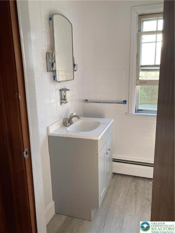 5984 Rte 412, Springfield Twp, PA 18077 - half bath with tile walls, a baseboard heating unit, vanity, and wood finished floors
