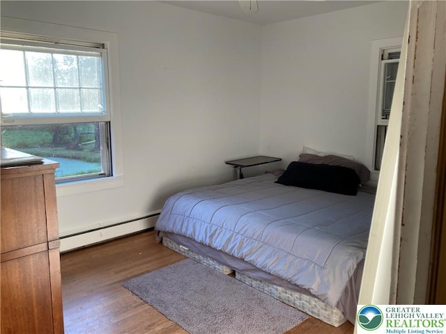 5984 Rte 412, Springfield Twp, PA 18077 - bedroom featuring baseboard heating, multiple windows, and wood finished floors