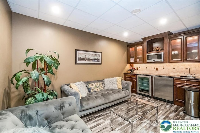 4260 W Wyndemere Cir, Lowhill Twp, PA 18078 - indoor wet bar with wine cooler, stainless steel microwave, refrigerator, wood finished floors, and tasteful backsplash