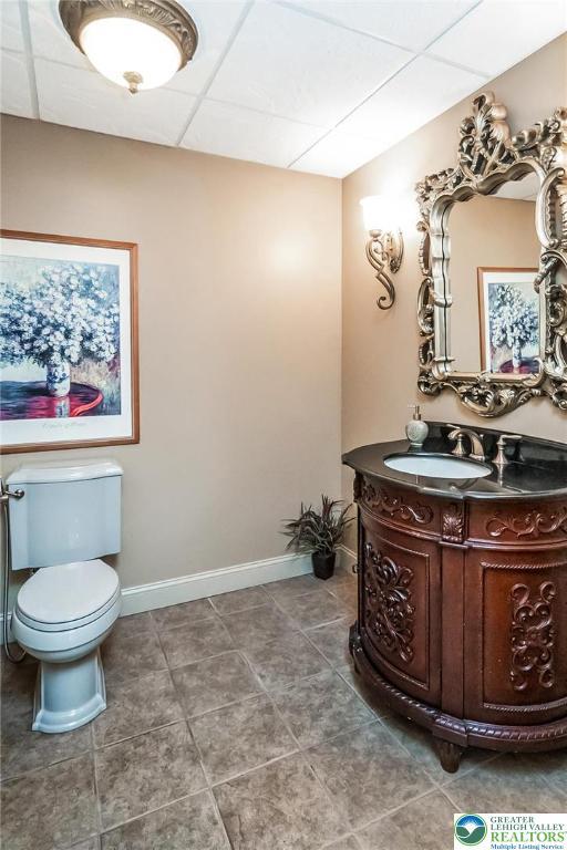4260 W Wyndemere Cir, Lowhill Twp, PA 18078 - half bathroom featuring vanity, a drop ceiling, and tile patterned flooring