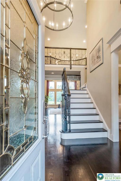 4260 W Wyndemere Cir, Lowhill Twp, PA 18078 - staircase with a towering ceiling, wood finished floors, and a chandelier