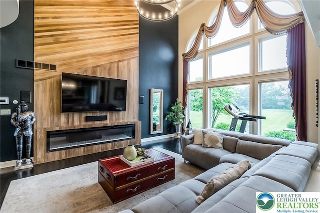 4260 W Wyndemere Cir, Lowhill Twp, PA 18078 - living area with a high ceiling, a glass covered fireplace, wood finished floors, and healthy amount of natural light