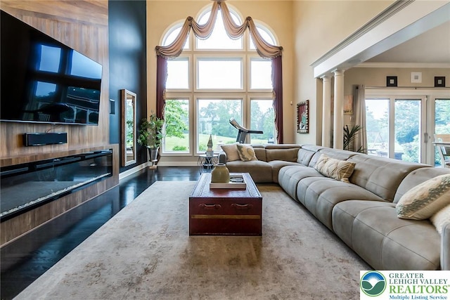 4260 W Wyndemere Cir, Lowhill Twp, PA 18078 - living area featuring wood finished floors, a high ceiling, decorative columns, and ornamental molding