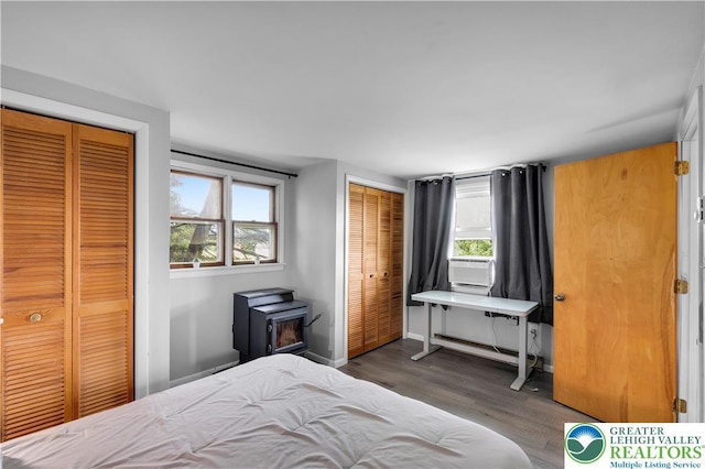8555 Mohr Ln, Weisenberg Twp, PA 18051 - bedroom featuring multiple closets, a wood stove, wood finished floors, and multiple windows